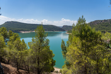 Naklejka na ściany i meble Paisaje verde de la costa en el mar, periodo vacacional de verano en el mara con aguas azules y arboles