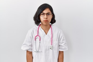 Young hispanic doctor woman wearing stethoscope over isolated background skeptic and nervous, frowning upset because of problem. negative person.