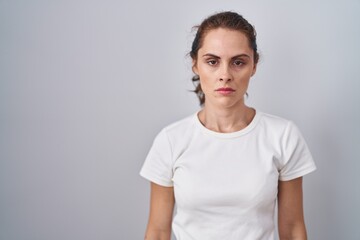 Beautiful brunette woman standing over isolated background skeptic and nervous, frowning upset because of problem. negative person.
