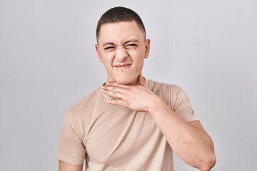 Fototapeta premium Young man standing over isolated background cutting throat with hand as knife, threaten aggression with furious violence
