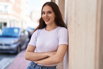 Young woman smiling confident standing with arms crossed gesture at street