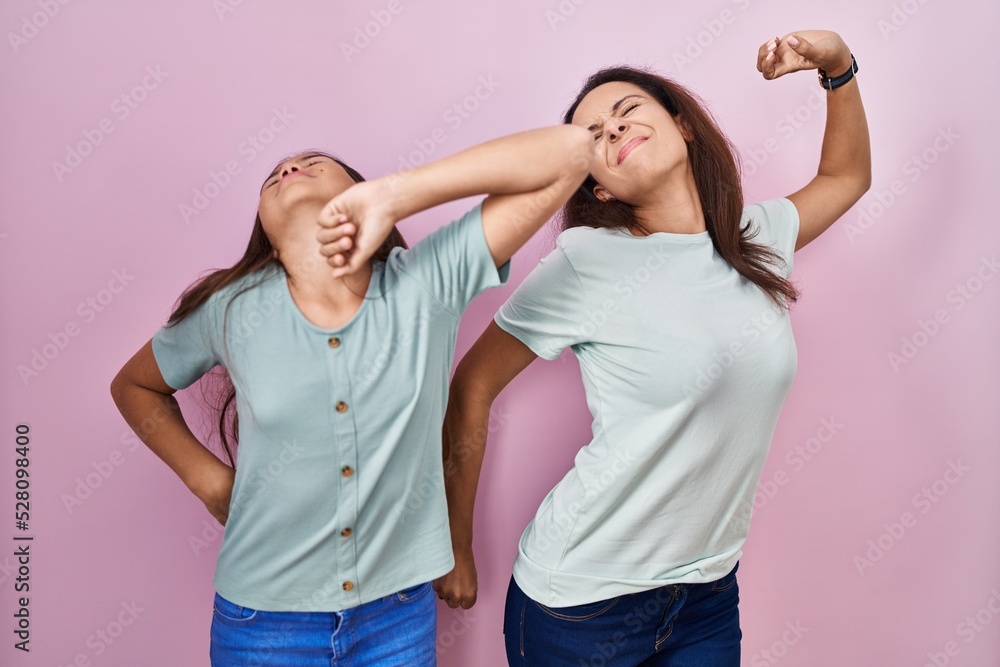 Canvas Prints Young mother and daughter standing over pink background stretching back, tired and relaxed, sleepy and yawning for early morning