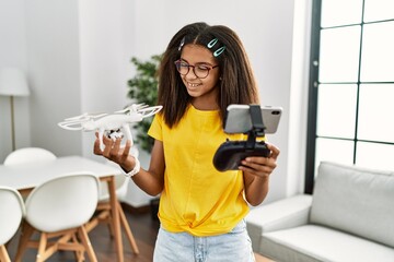 African american girl smiling confident holding drone at home