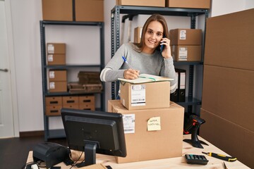 Young blonde woman ecommerce business worker talking on the smartphone at office