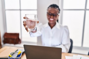 African american woman business worker using laptop drinking water at office