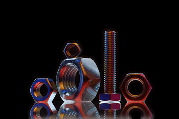 composition of bolts and nuts of different sizes on a black background