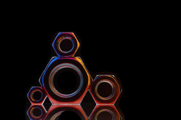 composition of bolts and nuts of different sizes on a black background