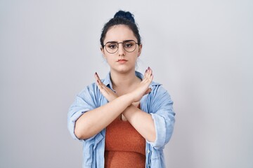 Young modern girl with blue hair standing over white background rejection expression crossing arms doing negative sign, angry face