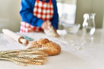 Senior man keading dough with hands at kitchen