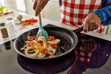Senior man cooking at kitchen