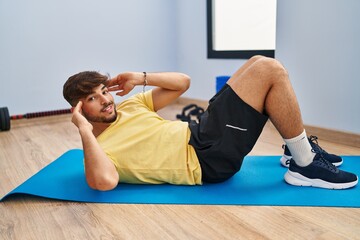 Young arab man smiling confident training abs exercise at sport center