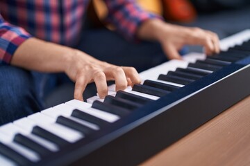 Obraz premium Young man musician playing piano keyboard at music studio