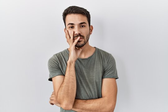 Young hispanic man with beard wearing casual t shirt over white background thinking looking tired and bored with depression problems with crossed arms.