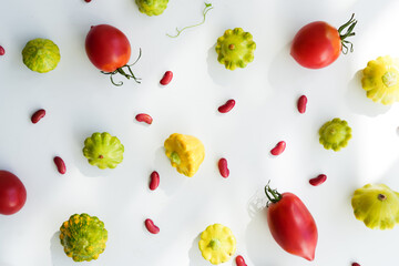 Vegetarian background. Fresh red beans, squash, red tomatoes, pattern on a white background