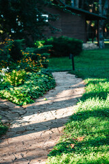 Path in the garden paved with decorative stone. Landscape design, vertical photography.