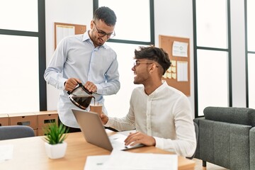 Two hispanic men business workers pouring coffee working at office