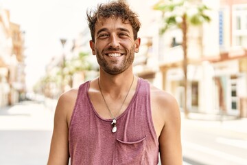 Young hispanic man smiling confident walking at street