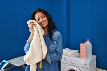 Young chinese woman smiling confident touching towel with face at laundry room © Krakenimages.com
