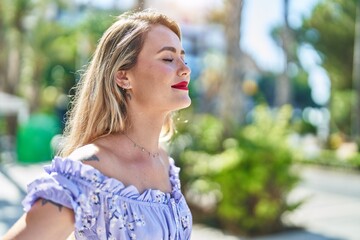 Young beautiful hispanic woman breathing with closed eyes at park