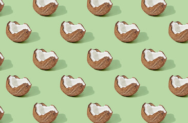 Pattern of half coconuts on green pastel background