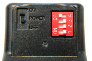 The button of the switch on a black device. On, off, power. Dp. White buttons on red synchronizer. Macro. Closeup.