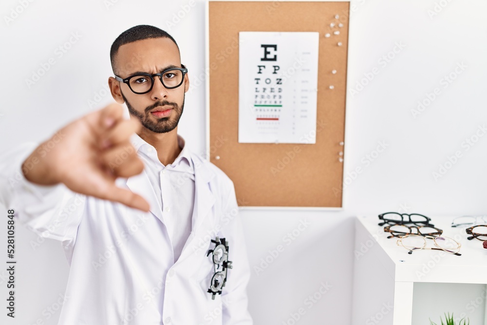 Poster african american optician man standing by eyesight test looking unhappy and angry showing rejection 