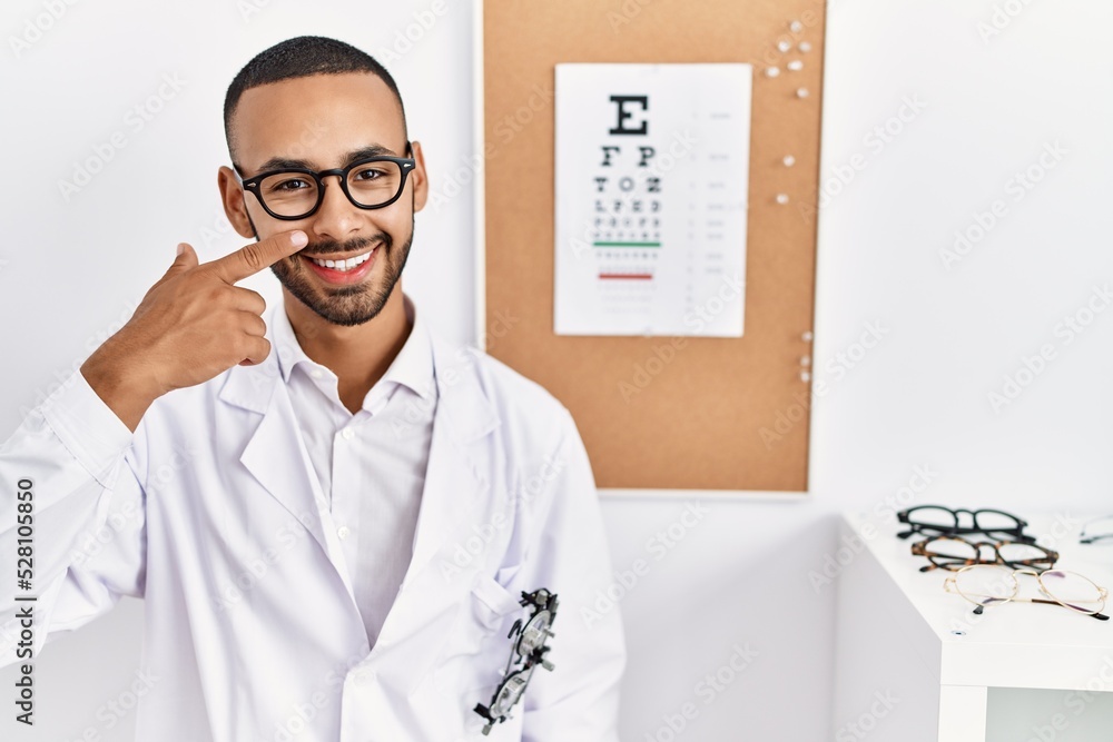 Sticker african american optician man standing by eyesight test pointing with hand finger to face and nose, 