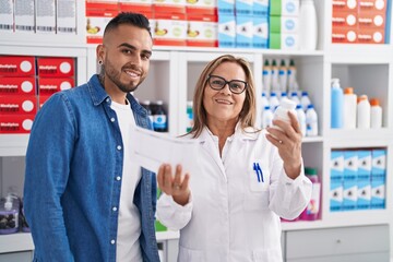Man and woman pharmacist reading pills label bottle and prescription at pharmacy