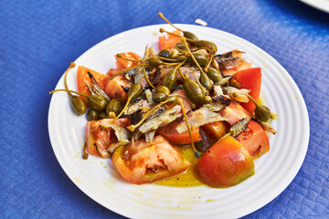  Plate of healthy tomato and fish salad on paper surface