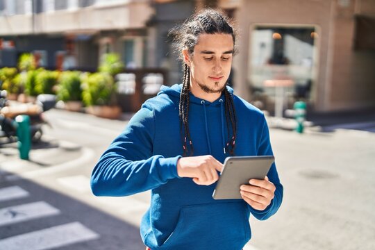 Young man using touchpad with serious expression at street