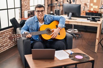 Young man musician having online classical guitar lesson at music studio