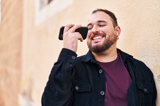 Young hispanic man smiling confident listening audio message by the smartphone at street