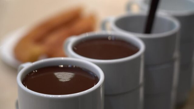 Detalle de unas tazas blancas llen&aacute;ndolas de chocolate caliente. Madrid, Espa&ntilde;a, septiembre de 2022.