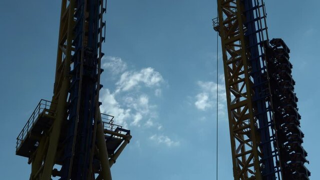 Detalle de una atracci&oacute;n de ca&iacute;da libre en un parque de atracciones.