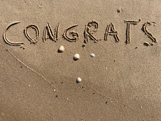 on the beach is carved with letters in the smooth sand the writing congrats