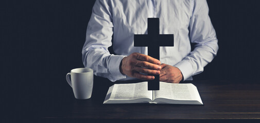 Open Bible prayer. The man and the cross of Jesus. crucifixion. Cross in hand. Calvary