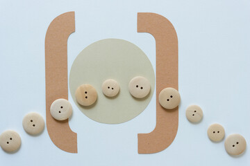 wooden buttons and brown paper shapes on a light blue background