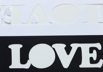 the word love represented with paper (black and white stencils)