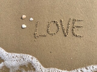 on the beach is carved with letters in the smooth sand the writing love