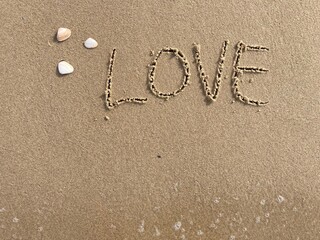 on the beach is carved with letters in the smooth sand the writing love