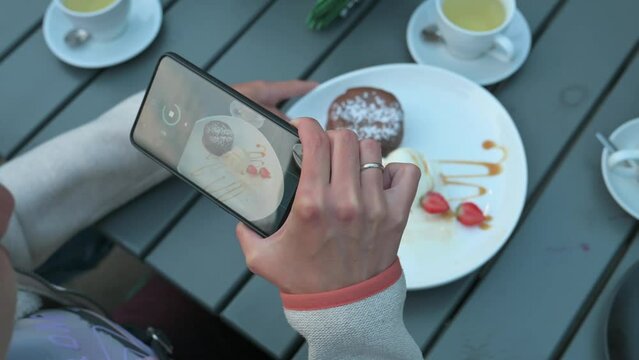 Woman taking fotos on breakfast. Shooting desser. 4k video footage