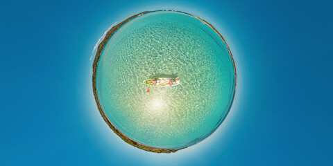 People kayaking in Mediterranean by Piana island and Petit Sperone beach Concept of environment. Tiny planet 360 view of kayak from Piantarella beach. Aerial view of Piana island in Corsica of France.