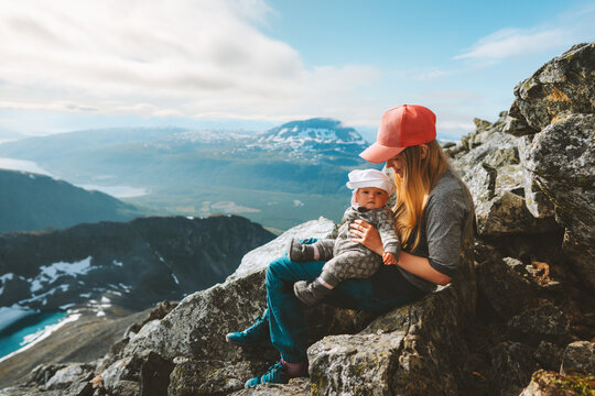 Mother and baby hiking together in mountains family travel outdoor active healthy lifestyle woman with child enjoying view vacations in Norway 