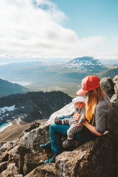 Family hiking in Norway mother and baby traveling in mountains healthy lifestyle mom with infant child together active vacations outdoor 