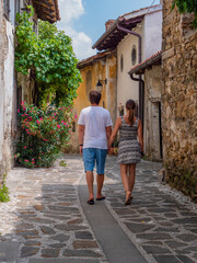 Fototapeta na wymiar Young couple on romantic walk through picturesque alley of an old historic town