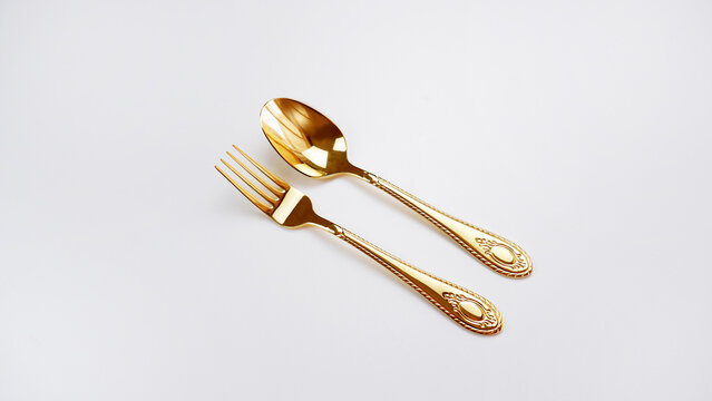 Golden spoon, fork and knife isolated dinner service set background