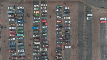 Fototapeta na wymiar Colorful cars parked on a parking lot viewed from above. Vertical aerial photo of cars on parking.