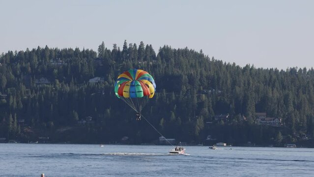 Parasail behind boat northern Idaho lake.  Family and tourist destination to view and enjoy mountain scenic lake. Northern Idaho Pacific Northwest. Summer recreation.