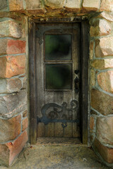 old wooden door with ornamental hinges surrounded with stone work