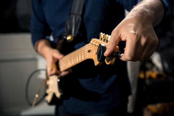 guitarist tuning electric guitar close-up